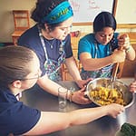 three students cooking