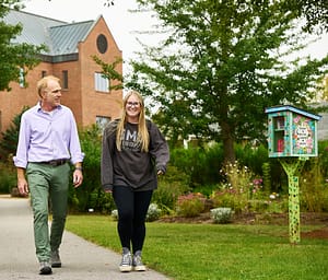 Professor Jerry Swope walks with a Saint Michael's College student on campus. 