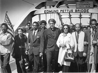 A member of the Society of Saint Edmund marches on the Edmund Pettis Bridge during the Civil Rights movement. 