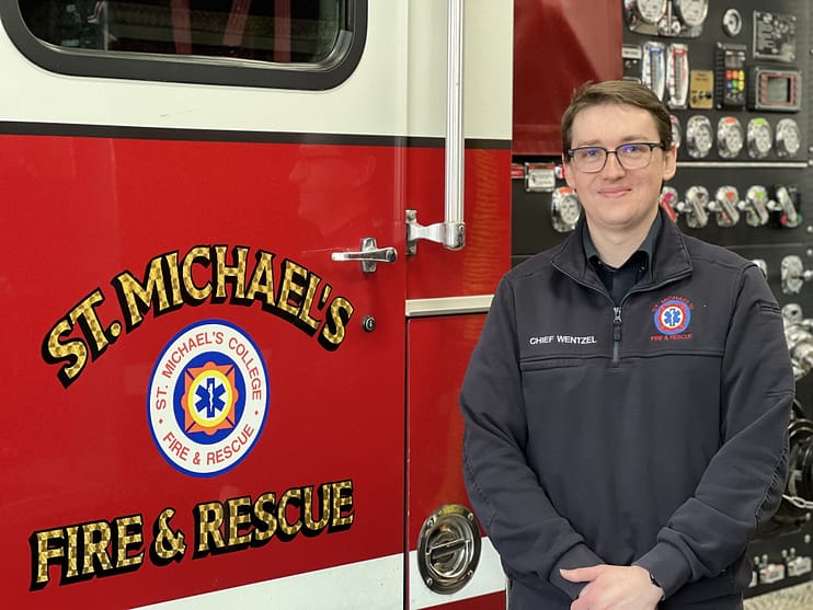 Saint Michael's Fire Chief Kyle Wentzel stands next to a Saint Michael's Fire and Rescue firetruck. 