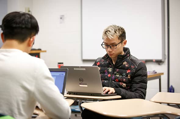 A student works on his computer during a class at Saint Michael's College. 