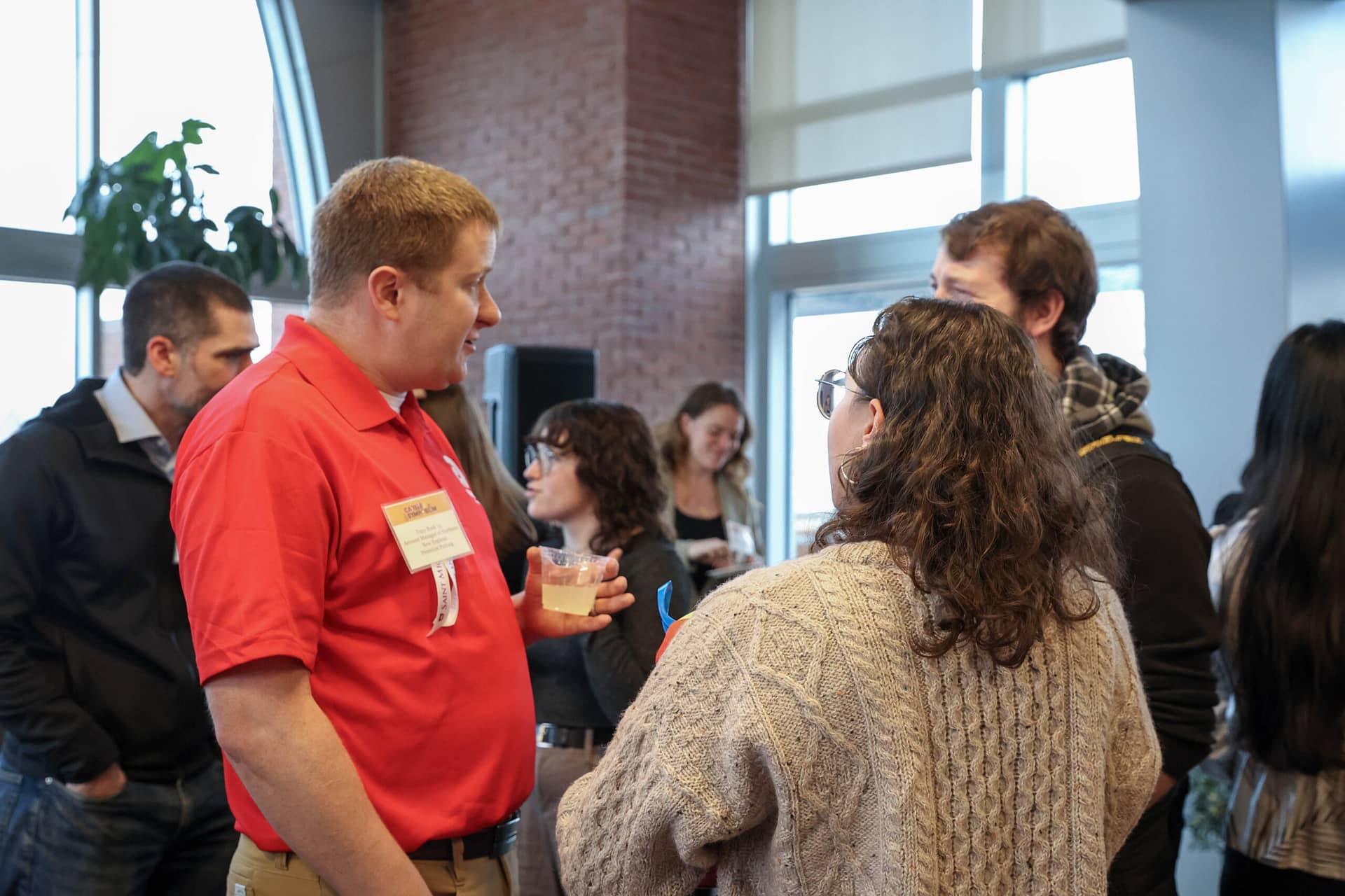 Two SMC students chatting with Tony Rock '15 at the Alumni Networking Reception.