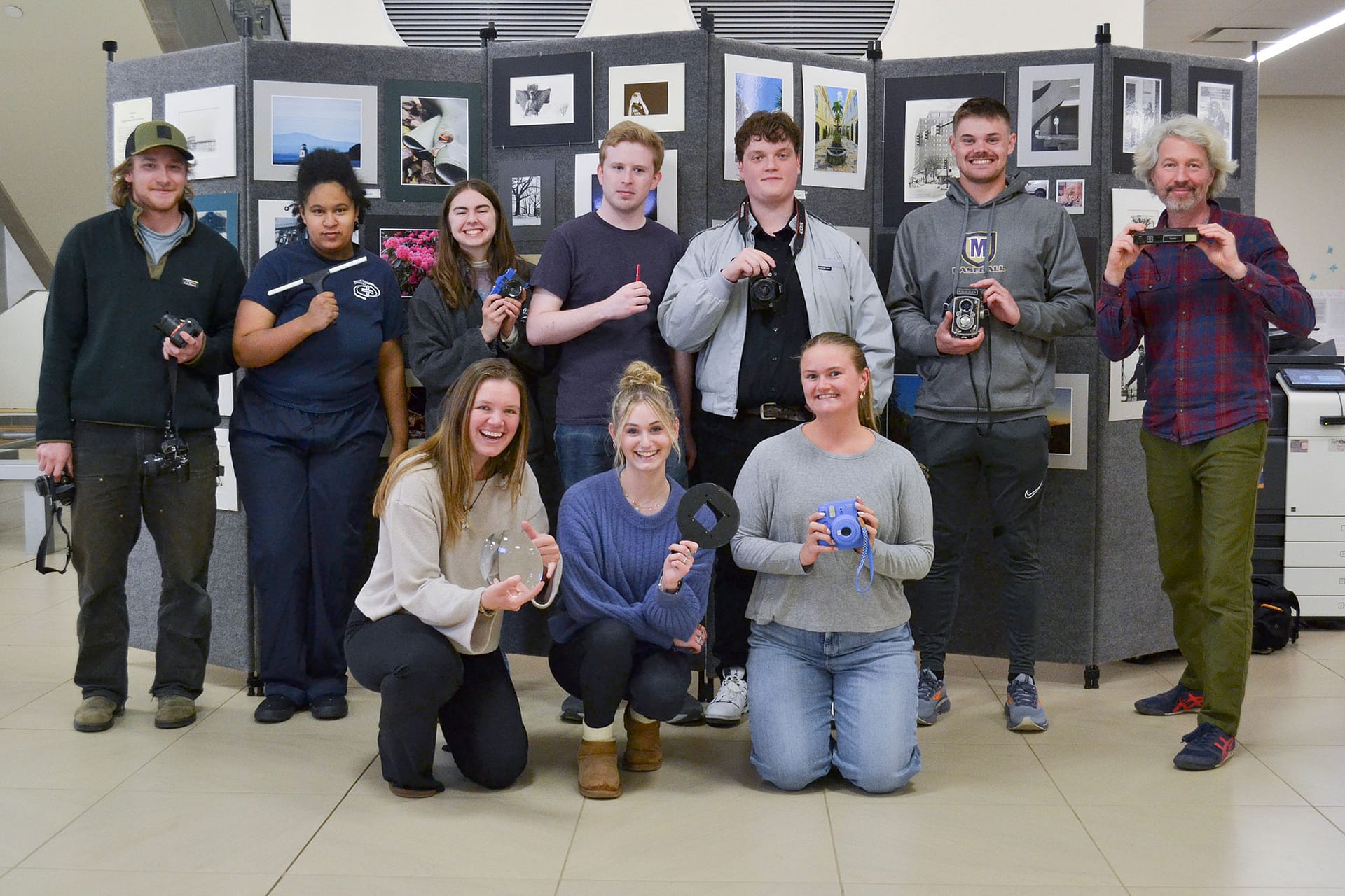 Members of the Saint Michael's College Photo Club pose at their annual art show. 